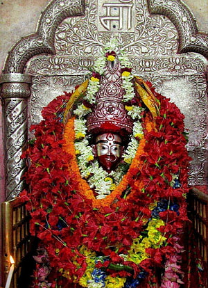 Decorated Hindu Deity Statue Adorned with Red Flower Garlands and Silver Crown HD phone wallpaper