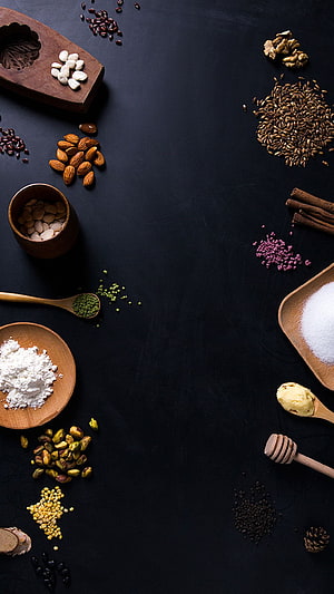 Dark Flat Lay of Nuts, Grains, and Spices Arranged on a Black Surface HD phone wallpaper