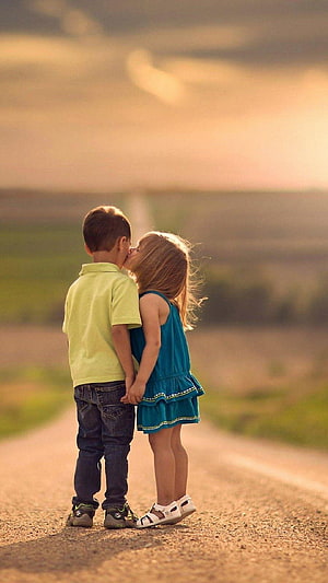 Cute little boy and girl kissing on a country road at sunset HD phone wallpaper