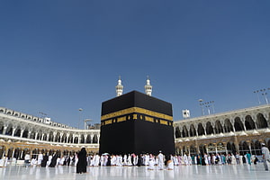 The Kaaba in Mecca with Pilgrims Performing Tawaf Under a Clear Blue Sky HD wallpaper