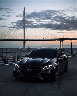 Black Mercedes-AMG C63 S Coupe Parked Near Cable-Stayed Bridge at Dusk HD phone wallpaper