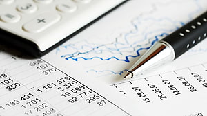 Financial Planning Workspace with Calculator, Pen, and Data Charts HD wallpaper