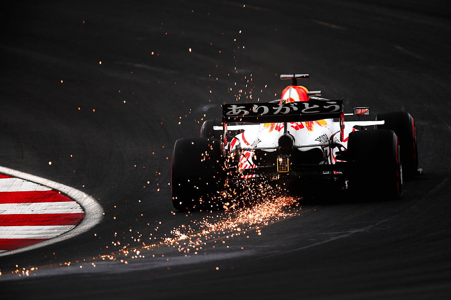 Red Bull Formula 1 car drifting through a corner with sparks flying on the racetrack HD wallpaper