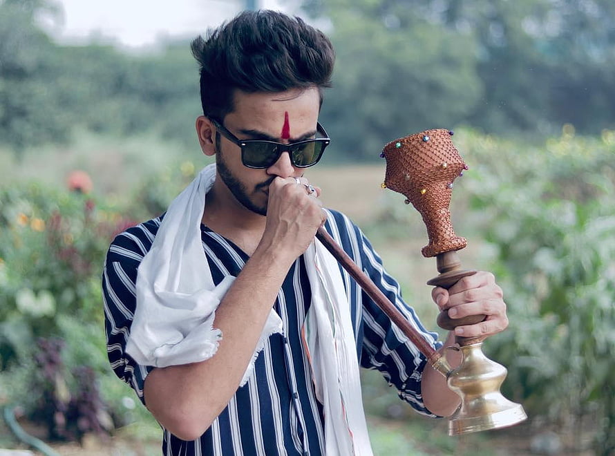 Elvish Yadav smoking hookah outdoors in striped shirt and sunglasses HD wallpaper