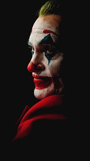 Joaquin Phoenix as The Joker in Dramatic Profile with Clown Makeup and Red Suit HD phone wallpaper