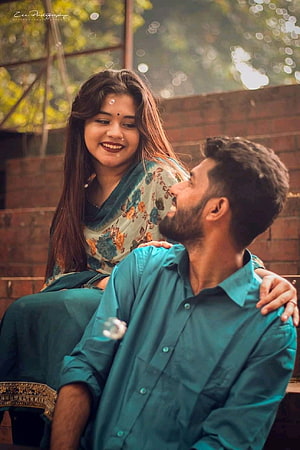 Bengali couple in teal attire sharing a tender moment outdoors HD phone wallpaper