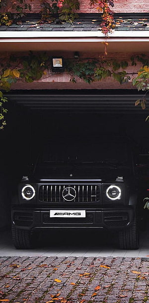 Black Mercedes-AMG G-Class SUV Parked in Garage with Autumn Leaves HD phone wallpaper