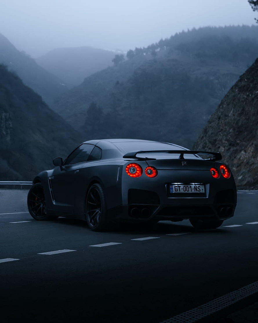 Matte Black Nissan GT-R R35 on a Misty Mountain Road at Dusk HD phone wallpaper