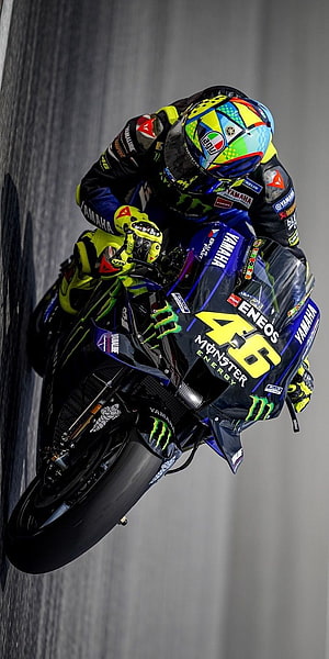 Valentino Rossi on Yamaha YZR-M1 in MotoGP cornering action with Monster Energy livery HD phone wallpaper