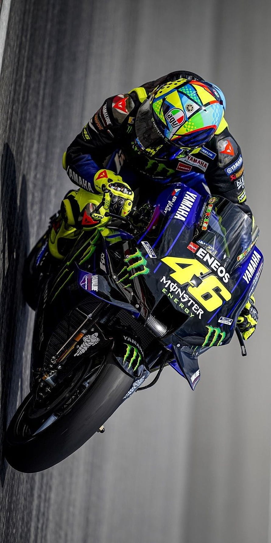 Valentino Rossi on Yamaha YZR-M1 in MotoGP cornering action with Monster Energy livery HD phone wallpaper