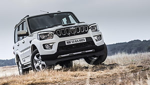 White Mahindra Scorpio S11 SUV on Dry Grassland Terrain HD wallpaper