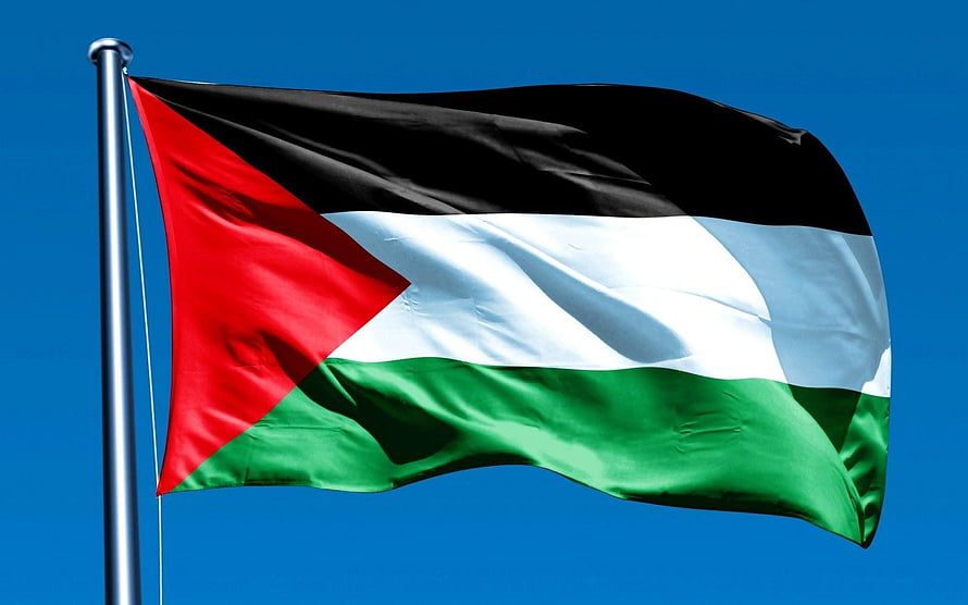 Palestinian National Flag Waving Against a Clear Blue Sky HD wallpaper