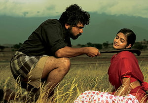 Paruthiveeran Film Still: Man Holding Sickle to Woman in Rural Field, Paruthiveeran HD wallpaper