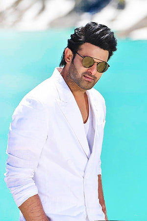 Hrithik Roshan in a white blazer and sunglasses posing against a turquoise background HD phone wallpaper