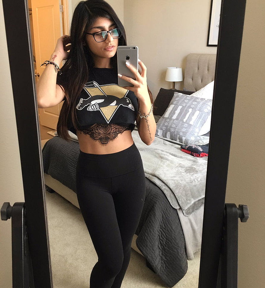 Woman in black crop top and leggings taking a mirror selfie in a bedroom, Mia K., mia khalifa HD phone wallpaper