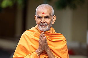 Mahant Swami ji in orange robes with hands pressed in prayer and tilak on forehead HD wallpaper