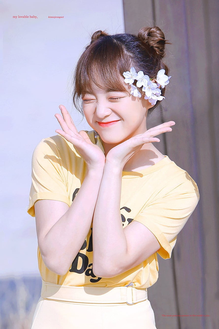 Kim Sejeong smiling with flower hair accessory in yellow top HD phone wallpaper