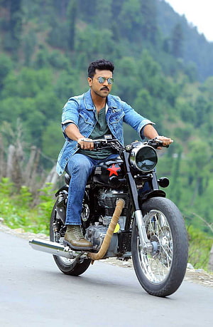 Ram Charan Riding Royal Enfield Motorcycle on Mountain Road in Denim Jacket HD phone wallpaper