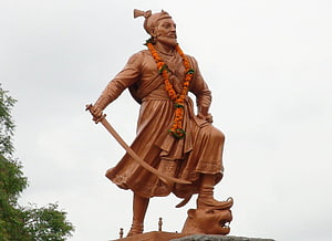 Sambhaji Maharaj Bronze Statue Holding Sword and Marigold Garland HD wallpaper
