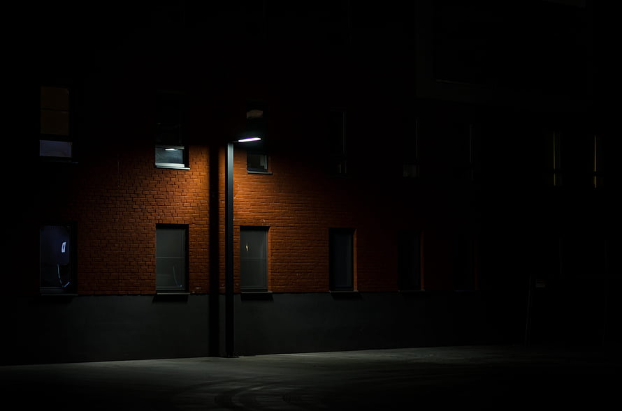 Moody Night Scene of a Brick Building Illuminated by a Single Streetlight HD wallpaper