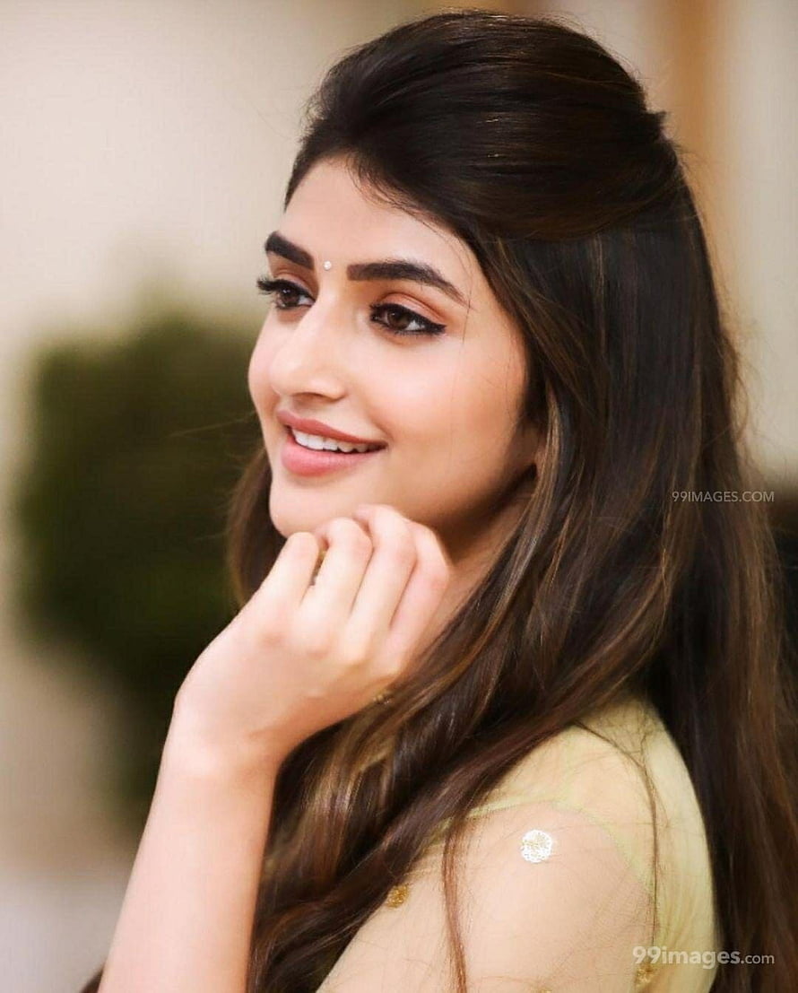 Sreeleela smiling portrait with long dark hair and elegant yellow outfit HD phone wallpaper