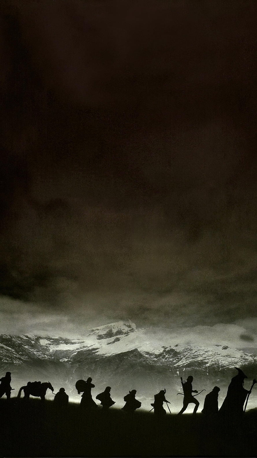 Silhouetted Fellowship of the Ring travelers crossing a dark landscape before a snow-capped mountain peak HD phone wallpaper