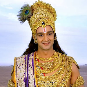 Krishna in ornate golden crown with peacock feather and traditional jewelry HD phone wallpaper