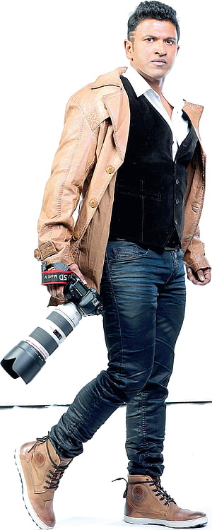 Punith Rajkumar in Tan Leather Jacket and Black Vest Holding DSLR Camera HD phone wallpaper
