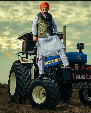 Punjabi Farmer Standing on Modified New Holland Tractor in Open Field HD phone wallpaper