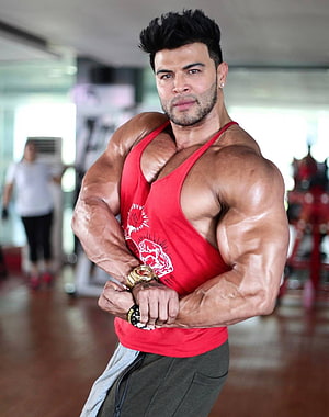 Muscular Indian Bodybuilder Flexing in Red Tank Top at Gym HD phone wallpaper