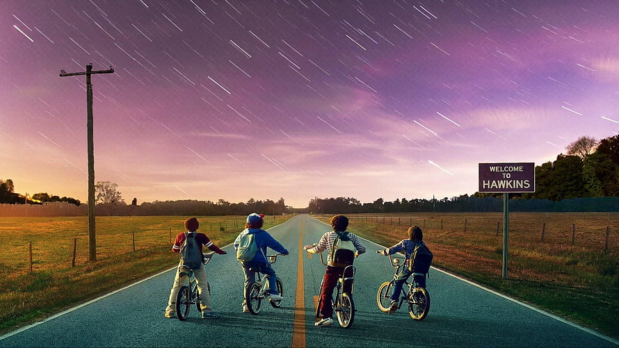 Stranger Things Kids Riding Bikes Down Road With Star Trails And Hawkins Sign HD wallpaper