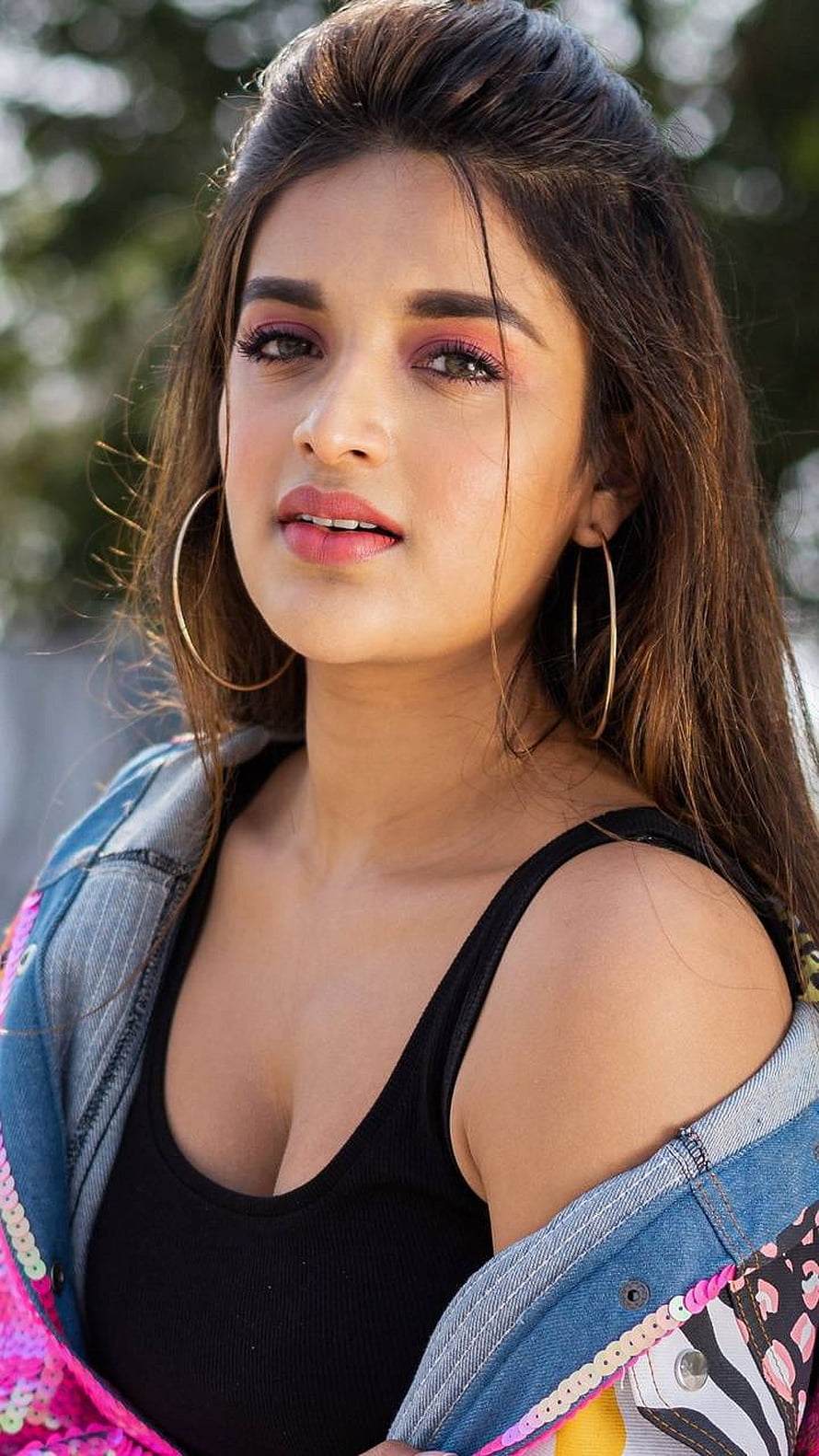 Nidhi Agerwal Portrait in Black Tank Top and Denim Jacket with Gold Hoop Earrings HD phone wallpaper