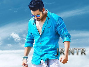 Jr NTR in a turquoise shirt and sunglasses against a bright blue sky HD wallpaper