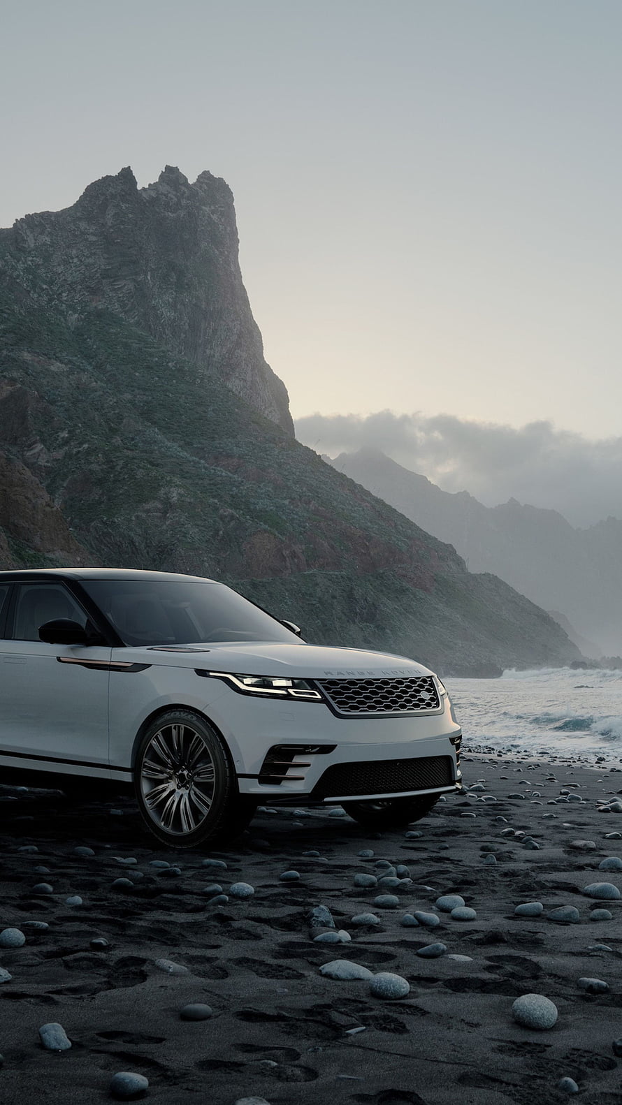 White Range Rover Sport parked on a black sand beach with rocky cliffs and ocean waves in the background HD phone wallpaper