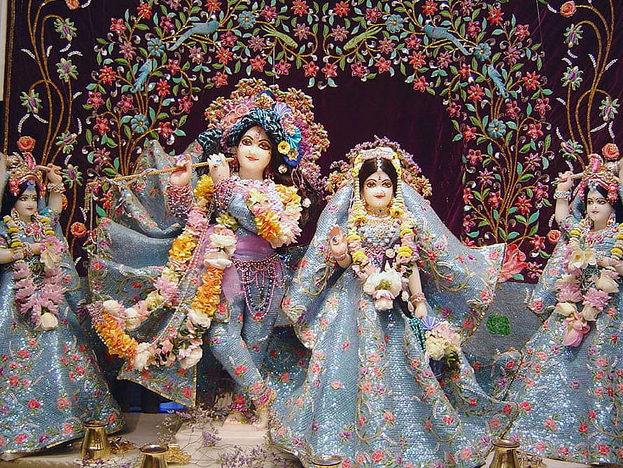 Radha Krishna Idol in Blue Floral Attire with Garlands and Floral Arch HD wallpaper