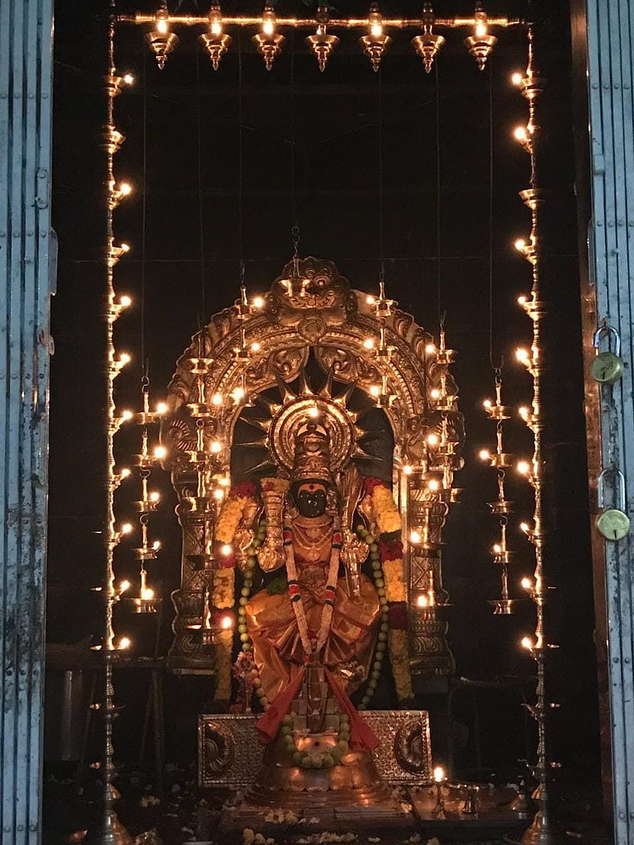 Kamakshi Devi Temple Idol Illuminated by Hanging Oil Lamps and Floral Garlands HD phone wallpaper