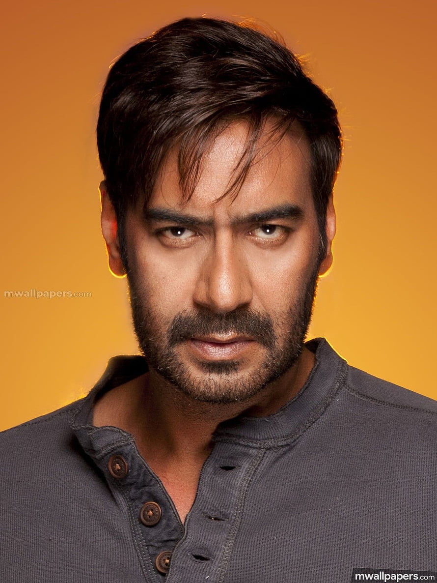 Ajay Devgan Intense Portrait Against Warm Orange Background HD phone wallpaper