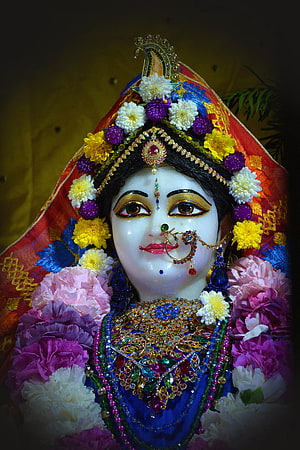 Beautifully adorned Goddess Kali idol with vibrant flowers and intricate jewelry HD phone wallpaper