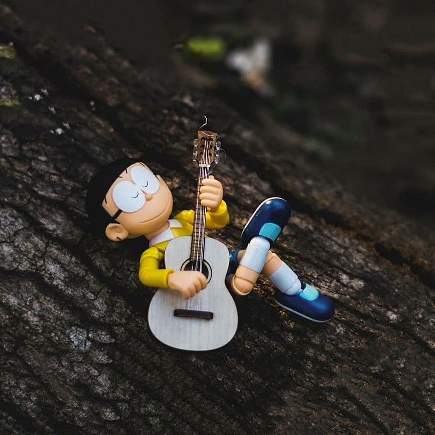Nobita Nobi Reclining on Tree Bark with Acoustic Guitar in Cozy Outdoor Setting HD phone wallpaper