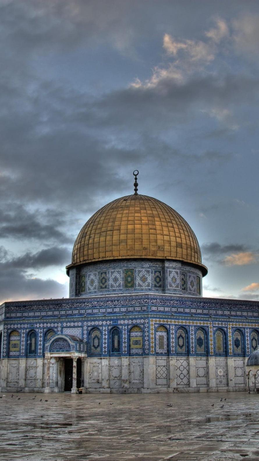 Dome of the Rock in Jerusalem with golden dome and intricate blue tilework under dramatic cloudy sky HD phone wallpaper