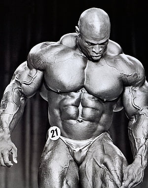 Black and white photo of a massive bodybuilder posing on stage with extreme muscle definition and vascularity HD phone wallpaper