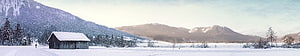 Serene Winter Landscape with Snow-Covered Barn and Mountain Range HD wallpaper