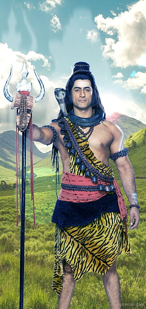Lord Shiva standing in green mountains holding trident with snake around neck HD phone wallpaper