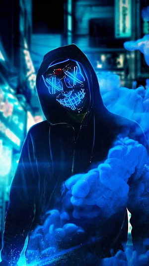 Mysterious hooded figure wearing a glowing neon blue skull mask in a dark cyberpunk alley with smoke HD phone wallpaper
