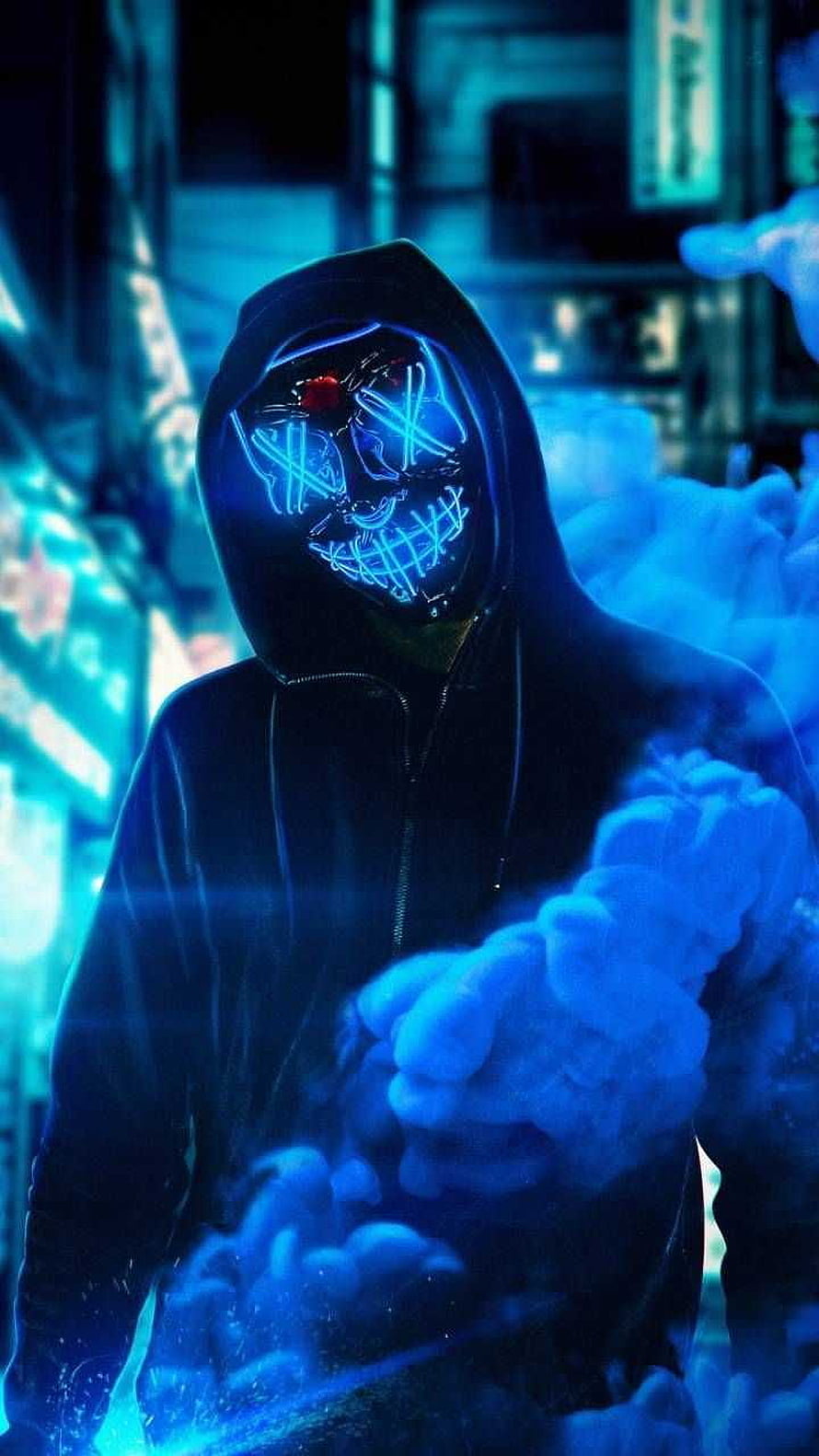 Mysterious hooded figure wearing a glowing neon blue skull mask in a dark cyberpunk alley with smoke HD phone wallpaper