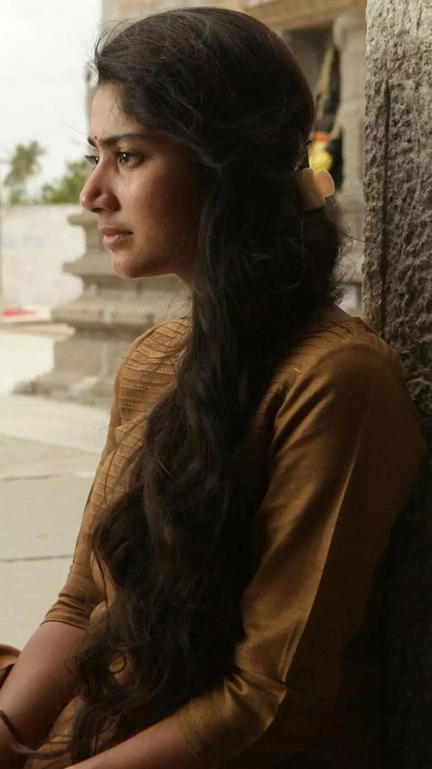 Sai Pallavi in a contemplative profile shot wearing a traditional brown outfit HD phone wallpaper