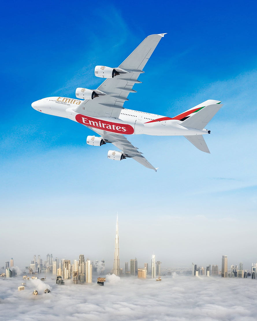 Emirates A380 Airplane Soaring Above Dubai Skyline and Burj Khalifa in Clear Blue Sky HD phone wallpaper