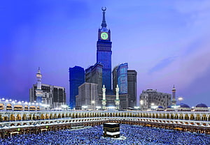 Makkah Royal Clock Tower Hotel and the Kaaba at dusk with pilgrims in the Grand Mosque courtyard HD wallpaper