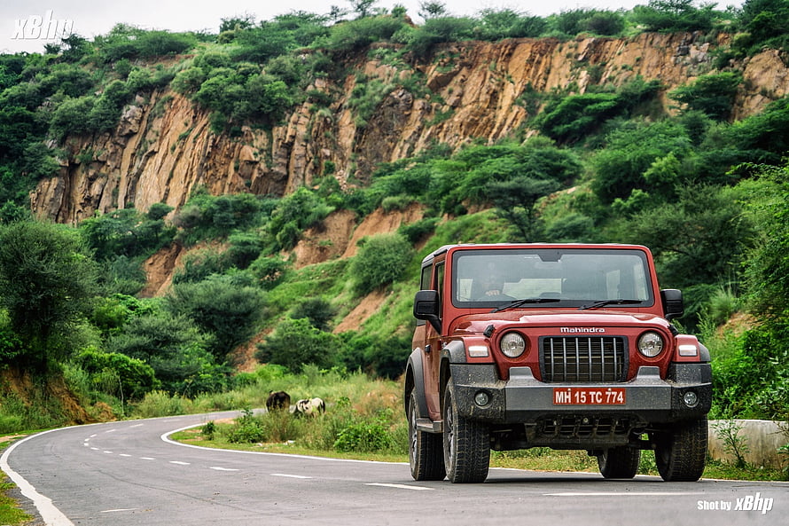 Red Mahindra Thar Driving on Winding Mountain Road with Green Hills HD wallpaper
