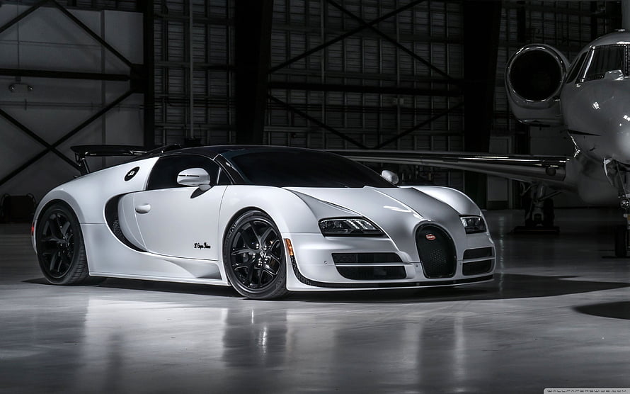 White Bugatti Veyron Super Sport parked in a hangar with a private jet in the background HD wallpaper